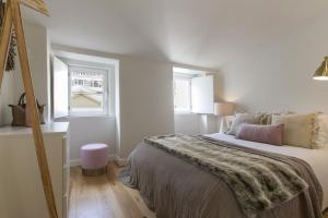 una camera da letto bianca con un letto e una finestra di The Romantic Nest - the Perfect Getaway at Downtown, 6th-floor no lift a Lisbona