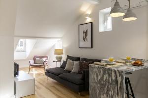 un soggiorno con un divano e un tavolo di The Romantic Nest - the Perfect Getaway at Downtown, 6th-floor no lift a Lisbona