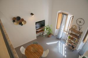 een woonkamer met een tafel en een televisie bij Casa Sant'Orsola - Appartamento nella città antica in Molfetta