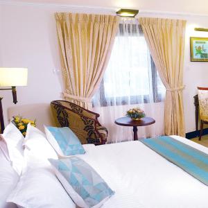 A bed or beds in a room at Hotel Grand Thekkady