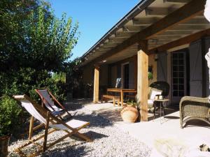 un patio avec une chaise, une table et une table dans l'établissement Gîte en Ardèche Méridionale - Les Berbéris, à Chandolas