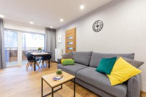 a living room with a couch and a clock on the wall at APARTAMENTY Słowackiego 5b, Karpacz in Karpacz