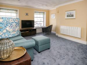 a living room with a couch and a tv at Embassy in Weymouth