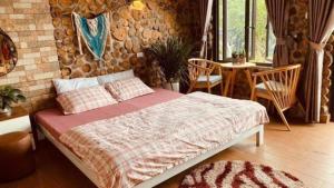 1 dormitorio con 1 cama, mesa y sillas en Cau May Tam Dao - Venuestay en Tam Ðảo