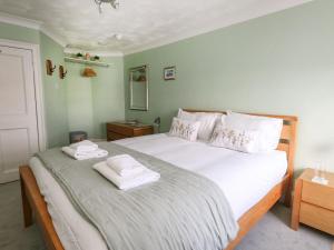 sypialnia z dużym białym łóżkiem z 2 ręcznikami w obiekcie Embassy w mieście Weymouth