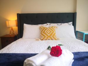 a bedroom with a bed with a red rose on it at Rose Room in Auckland