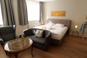 een hotelkamer met een bed en een stoel bij Herberge KAFFETIET in Wismar