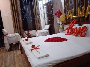 a bed with red roses and a declaration of love on it at Vinee's Kitchen and Motel in Koynanagar