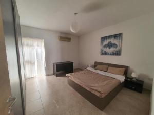 a bedroom with a large bed and a window at Belvedere Apartment in Sliema