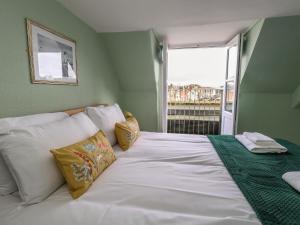 a bedroom with a large white bed with a window at Monarch in Weymouth