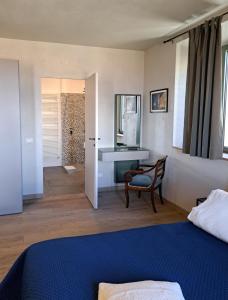 een slaapkamer met een bed, een bureau en een stoel bij Casa Mustiola in Montalcino