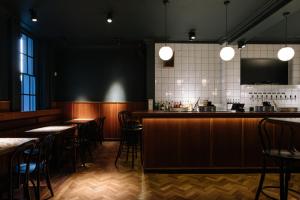 ein Restaurant mit Tischen und Stühlen und einer Bar in der Unterkunft The 1852 Hotel - Self Check-in in Belfast