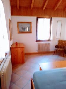 ein Zimmer mit einem Sofa, einem Tisch und zwei Fenstern in der Unterkunft casetta Vittorio in Mezzolago