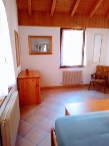 a room with a couch and a table and two windows at casetta Vittorio in Mezzolago