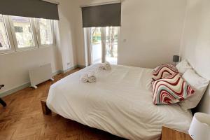 - une chambre avec un grand lit blanc et 2 serviettes dans l'établissement Banzão home PineForest family &friends pool garden, à Colares