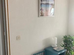 Ecke eines Zimmers mit einem blauen Tisch und einem Bild in der Unterkunft Appartement Le Lavandou, 2 pièces, 4 personnes - FR-1-308-167 in Le Lavandou