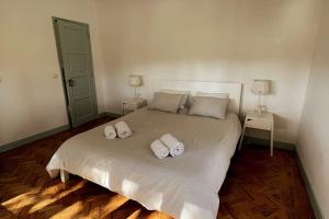 - une chambre avec un grand lit et 2 serviettes dans l'établissement Banzão home PineForest family &friends pool garden, à Colares