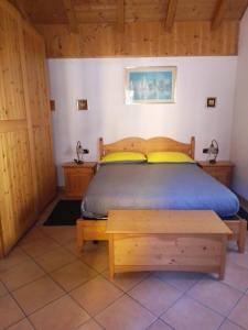 a bedroom with a bed and wooden cabinets at casetta Vittorio in Mezzolago