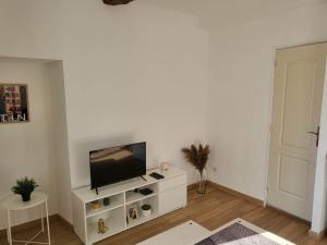 a living room with a flat screen tv on a white cabinet at Studio sur le port de Toulon in Toulon