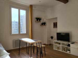 een woonkamer met een tafel en een televisie bij Studio sur le port de Toulon in Toulon