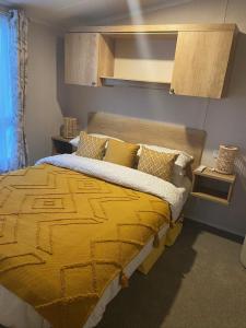 a bedroom with a bed with a yellow blanket at The Cornish Hideaway in Poughill