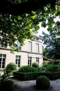 una casa blanca con arbustos delante en Ter Heide (Kaprijke - Lembeke) en Lembeke