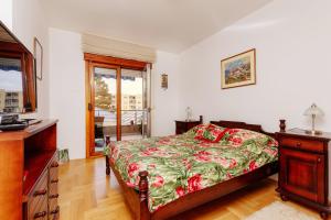 a bedroom with a bed and a dresser and a window at Apartment Sahala in Tivat