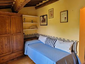 a bedroom with a bed and a wooden cabinet at Casa Lucia in Monticiano