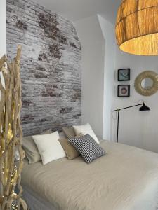 um quarto com uma cama com uma parede de tijolos em CASA EULALIA em Málaga