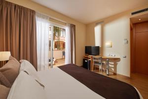 a hotel room with a bed and a desk and a television at Sercotel Hotel Zurbarán Palma in Palma de Mallorca