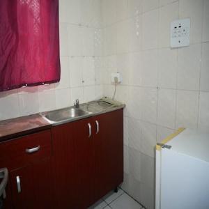 a bathroom with a sink and a red window at Arsenal's Lodge in Abuja