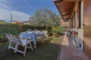 einen Tisch mit Stühlen und Weingläsern auf einer Terrasse in der Unterkunft La Sammartina Garden Apartment x6 in Chiesol del Fosso