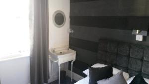 a bathroom with a sink and a bed and a mirror at The Derby Hotel in Blackpool +79 photos
