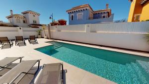 a swimming pool in front of a house at Villa Cerezo - A Murcia Holiday Rentals Property in Torre-Pacheco