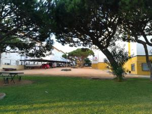 um parque com uma mesa de piquenique e um edifício amarelo em El Vigía Beach. Mazagón em Mazagón
