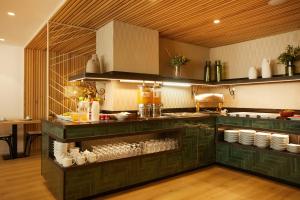 a kitchen with green cabinets and a counter with dishes at Sercotel Hotel Zurbarán in Palma de Mallorca