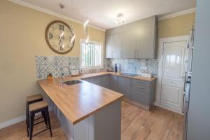 a kitchen with a counter and a clock on the wall at Villa Leonie, private pool, jacuzzi, 8p in Orba