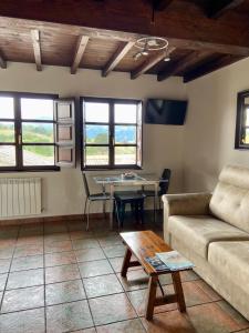 a living room with a couch and a table at Casa y Apartamentos La Maestra in Arriondas