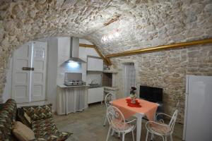 sala de estar con mesa y cocina en B&B CASAVACANZE CHIESA MADRE, en Carovigno