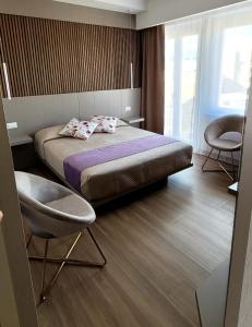 a bedroom with a bed and two chairs in it at Th Luxury Central in Catania