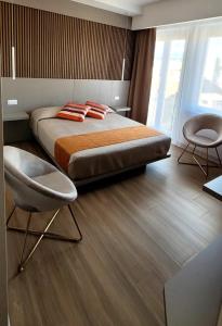 a bedroom with a large bed and two chairs at Th Luxury Central in Catania