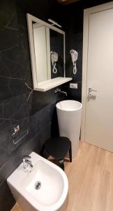 a bathroom with a sink and a mirror and a stool at Th Luxury Central in Catania