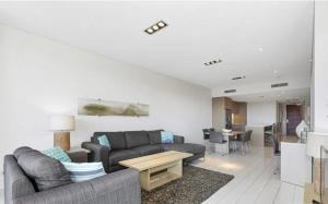 a living room with a couch and a table at Luxury Apartments at Bells Blvd in Kingscliff
