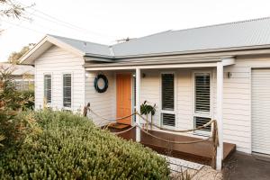 a small white house with a porch and a door at Romantic retreat in Mornington Peninsula Heartland in Dromana