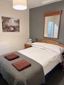 um quarto com uma cama grande com duas toalhas em The Coach House at The Bull Inn em Milton Keynes
