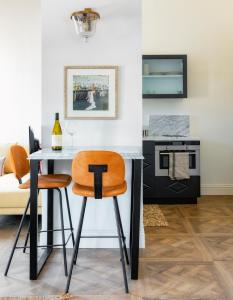 eine Küche mit einem Tisch und 2 orangefarbenen Stühlen in der Unterkunft Kubler's House - By Beach Apartments TLV in Tel Aviv