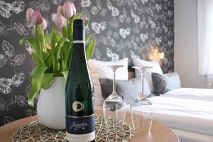 克罗夫Weingut Markus Junglen的桌子上放有一瓶葡萄酒和两杯酒