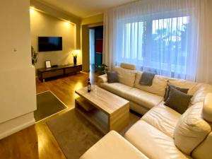 a living room with a white couch and a coffee table at Yose Apartment - 160 m2 na wyłączność in Poznań