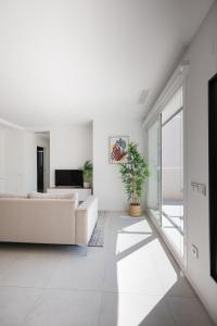 Turquesa del Mar - Max Beach Golf - Large Sunny Terrace Apartment في بلايا فلامنكا: غرفة معيشة مع أريكة بيضاء ونافذة كبيرة