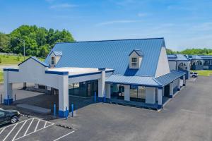 a building with a blue roof and a parking lot at Days Inn by Wyndham Owensboro in Owensboro